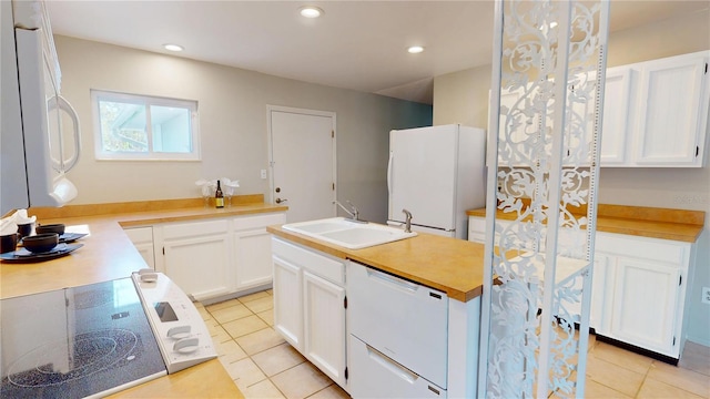 kitchen featuring light countertops, white appliances, white cabinets, and a sink