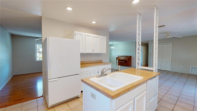 kitchen with white appliances, a sink, white cabinetry, a ceiling fan, and light countertops