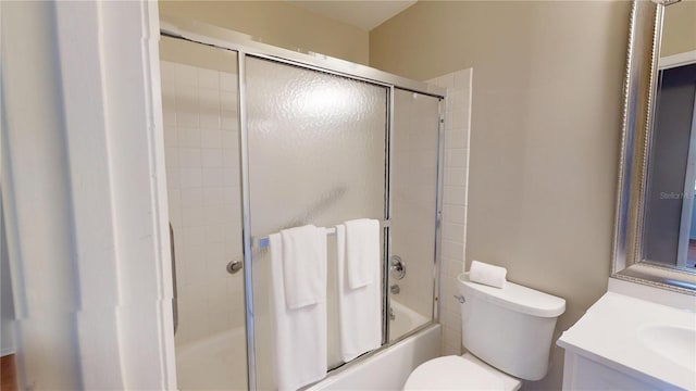 full bath with toilet, enclosed tub / shower combo, and vanity