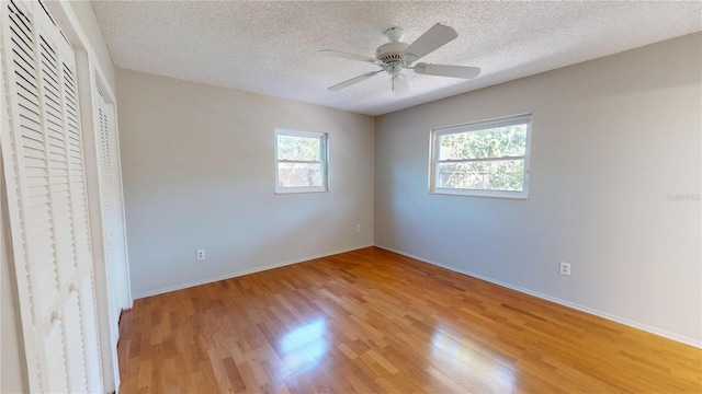 unfurnished bedroom with baseboards, light wood-style flooring, and a textured ceiling