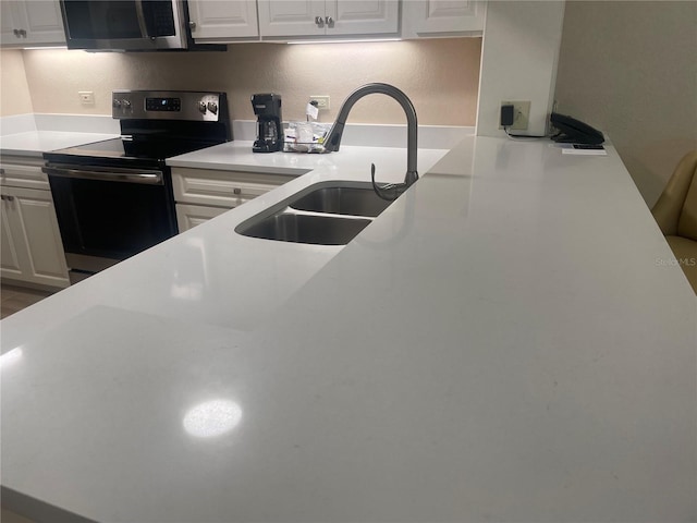 kitchen with sink, stainless steel appliances, and white cabinetry