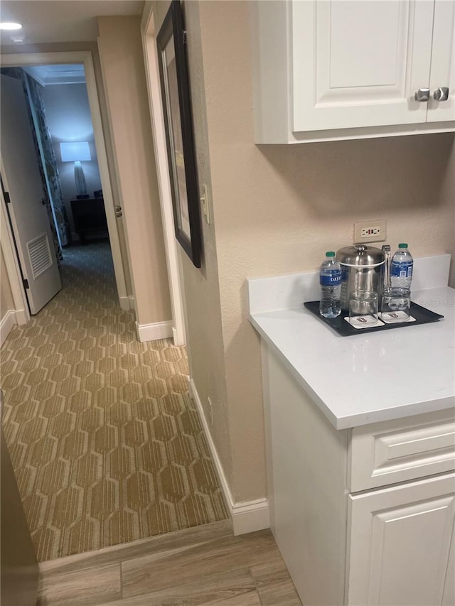 interior space with white cabinetry and light hardwood / wood-style flooring