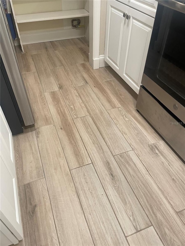 details featuring white cabinets and light wood-type flooring