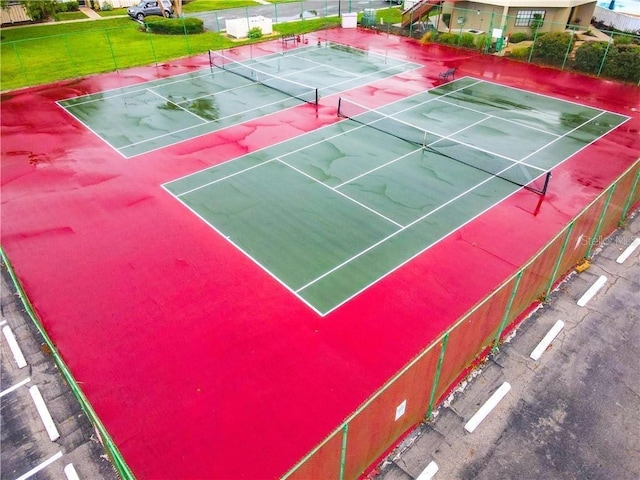 view of tennis court with a yard