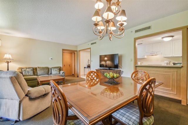 dining area featuring dark carpet, a textured ceiling, and a chandelier