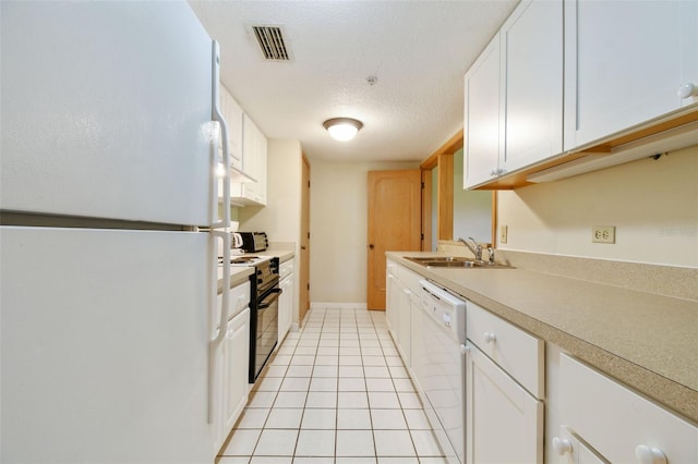 kitchen with light tile patterned flooring, white cabinets, white appliances, a textured ceiling, and sink