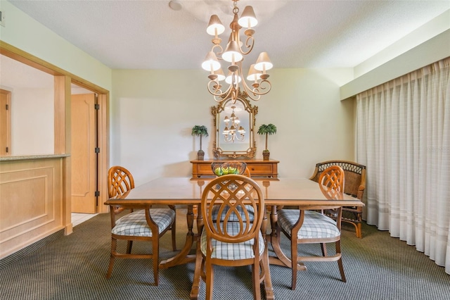 dining room with a textured ceiling, a chandelier, and carpet