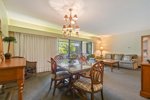 dining space with carpet flooring, a textured ceiling, and a chandelier