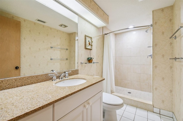 bathroom featuring walk in shower, vanity, toilet, and tile patterned floors