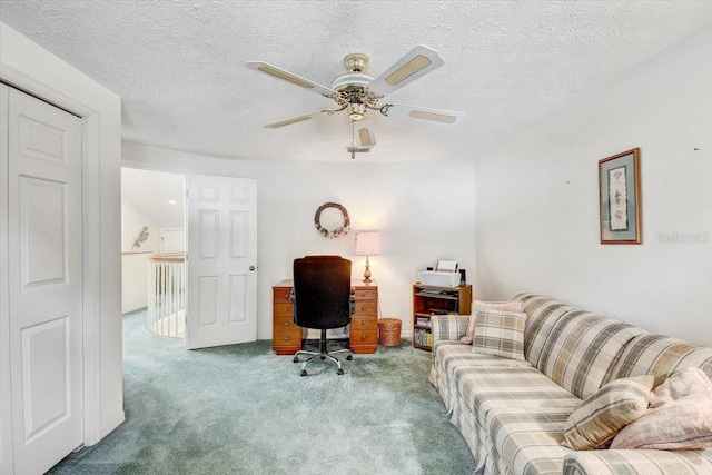 home office featuring a textured ceiling, carpet floors, and ceiling fan