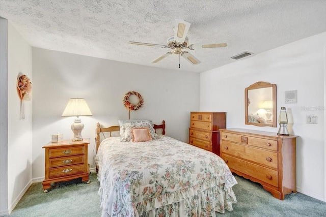 carpeted bedroom featuring ceiling fan and a textured ceiling