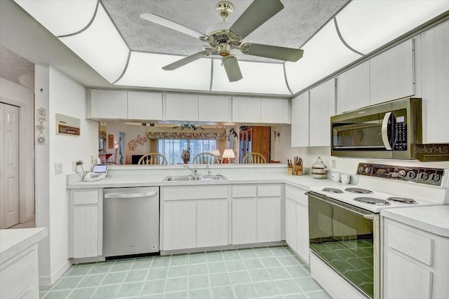 kitchen with ceiling fan, stainless steel appliances, a textured ceiling, sink, and light tile floors