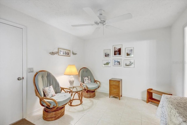 living area featuring a textured ceiling, ceiling fan, and light tile floors