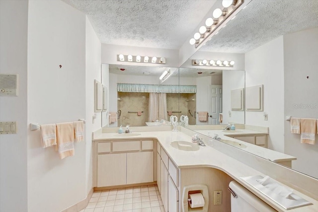 bathroom featuring tile floors, double vanity, toilet, and a textured ceiling