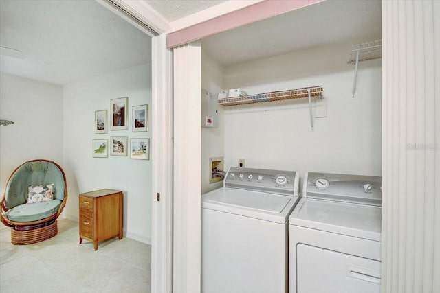 laundry area featuring washer and clothes dryer, hookup for a washing machine, and light tile flooring