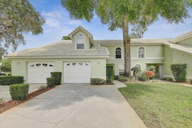 view of front of home with a front yard and a garage