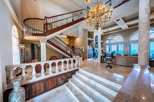 stairway featuring a towering ceiling, an inviting chandelier, and a healthy amount of sunlight