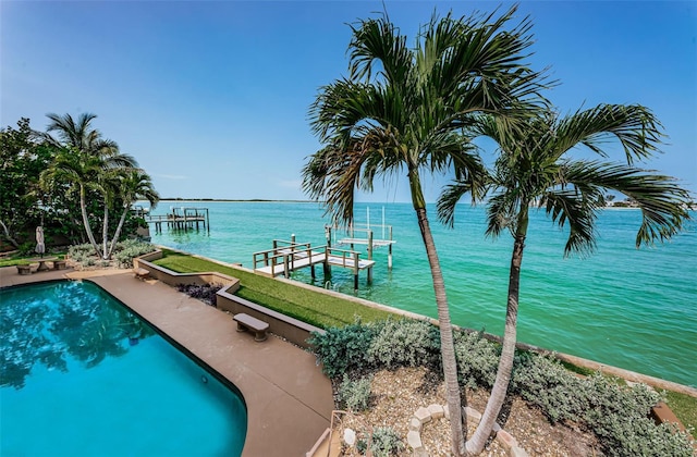 view of swimming pool featuring a water view and a dock