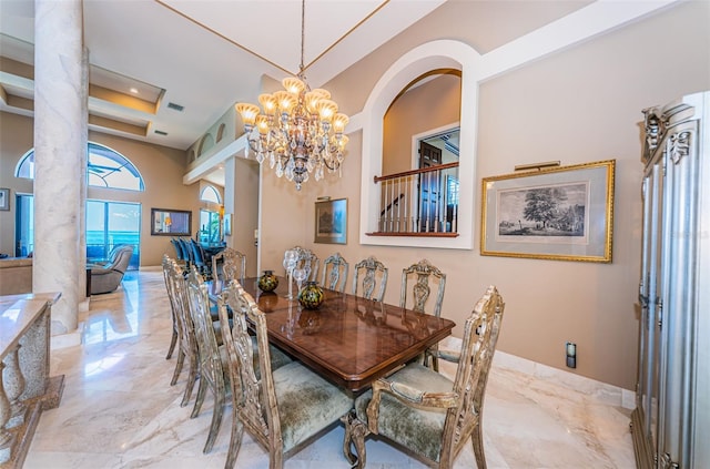 dining area featuring an inviting chandelier, ornate columns, a tray ceiling, and tile floors