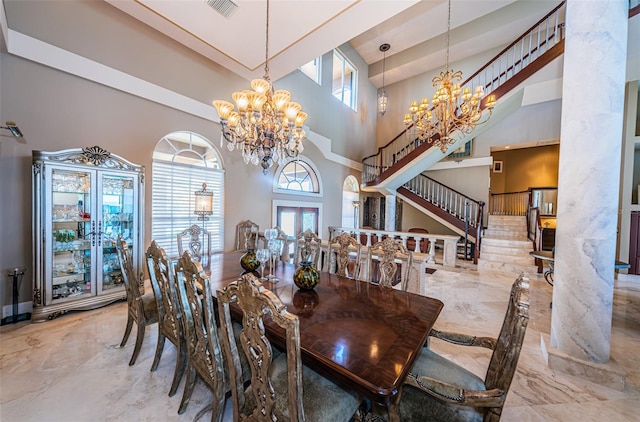 dining room featuring a towering ceiling, an inviting chandelier, and light tile flooring