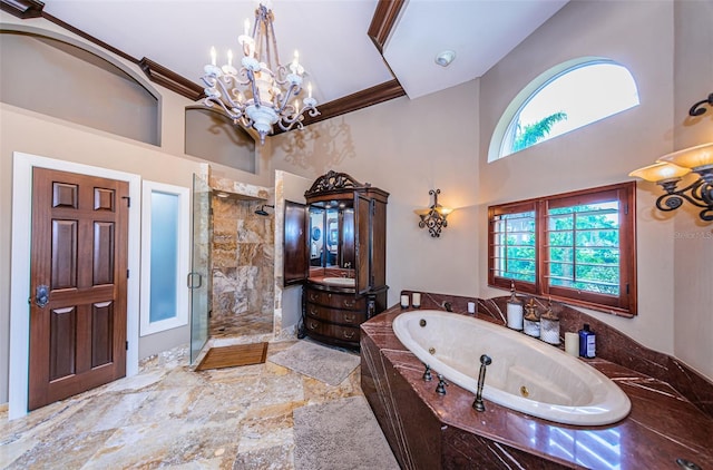 bathroom featuring tile flooring, an inviting chandelier, vanity with extensive cabinet space, a towering ceiling, and separate shower and tub