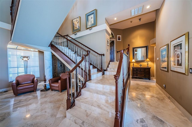 stairs featuring a high ceiling and light tile floors