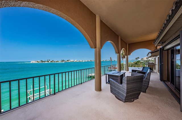 view of terrace featuring an outdoor living space, a balcony, and a water view