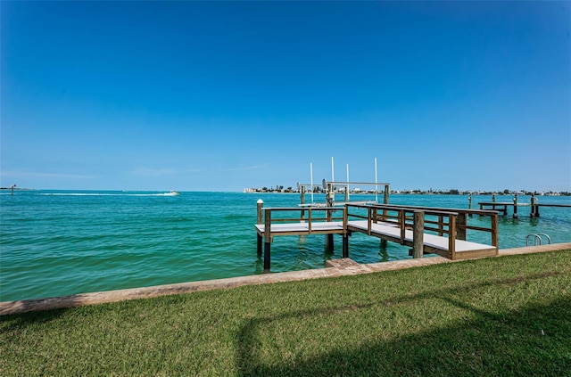 view of dock with a yard and a water view