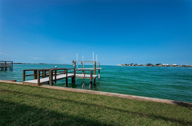 view of dock with a water view and a yard