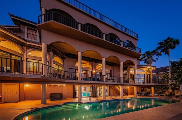 pool at night with a patio area and central AC