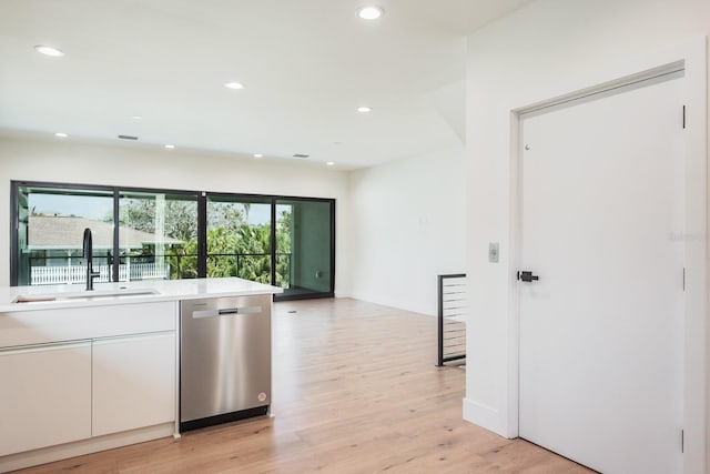 kitchen with white cabinetry, light hardwood / wood-style flooring, sink, and stainless steel dishwasher