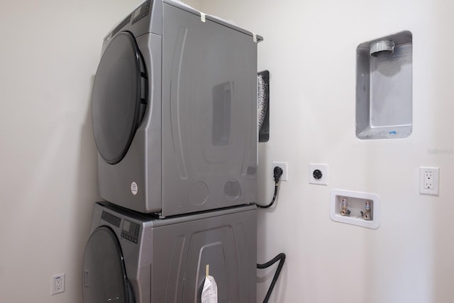 washroom featuring stacked washer and clothes dryer