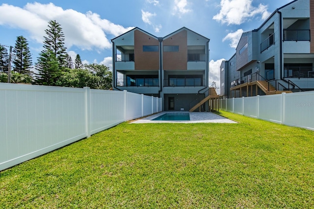 view of yard featuring a balcony and a fenced in pool