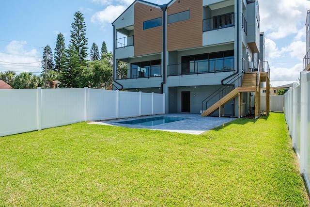 view of yard featuring a balcony and a fenced in pool