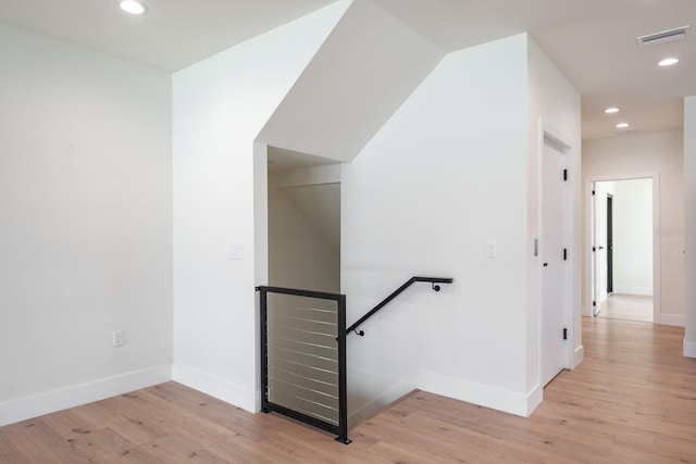 stairs with light hardwood / wood-style floors