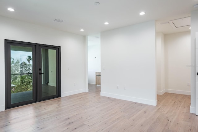 unfurnished room with french doors and light wood-type flooring