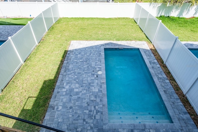 view of swimming pool featuring a yard