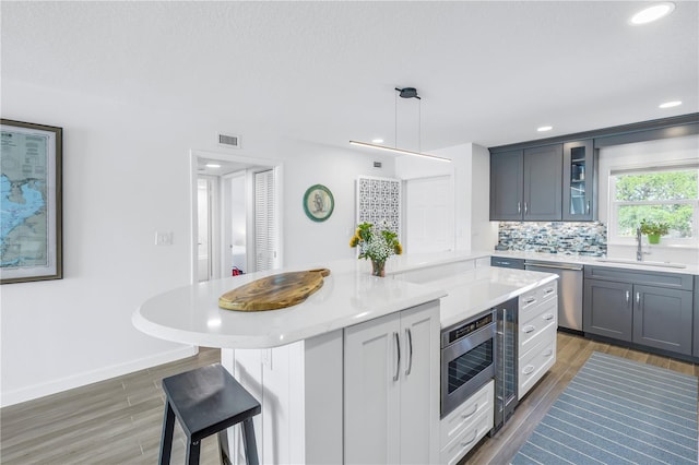 kitchen featuring a kitchen island, pendant lighting, sink, tasteful backsplash, and dishwasher