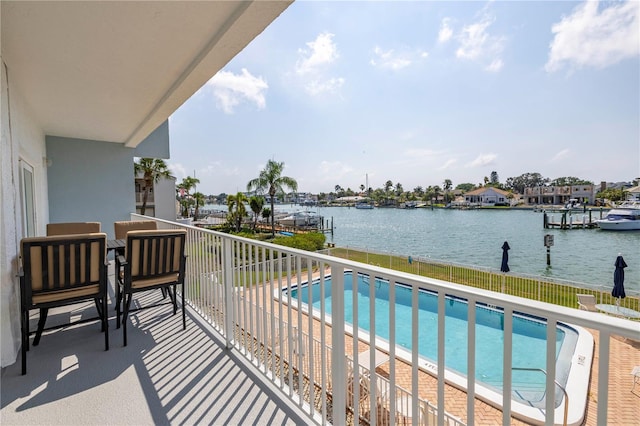 balcony featuring a water view and a fenced in pool