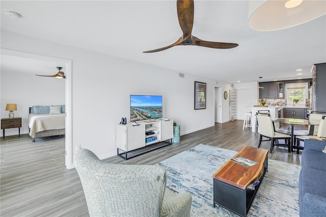 living room with ceiling fan and hardwood / wood-style floors