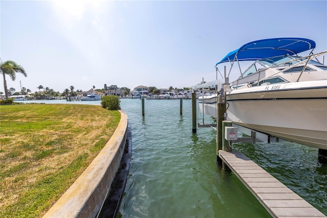 dock area with a lawn and a water view