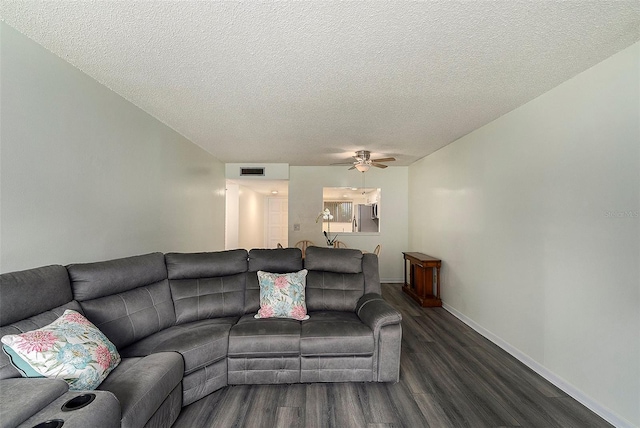 living room featuring a textured ceiling, ceiling fan, and dark hardwood / wood-style flooring