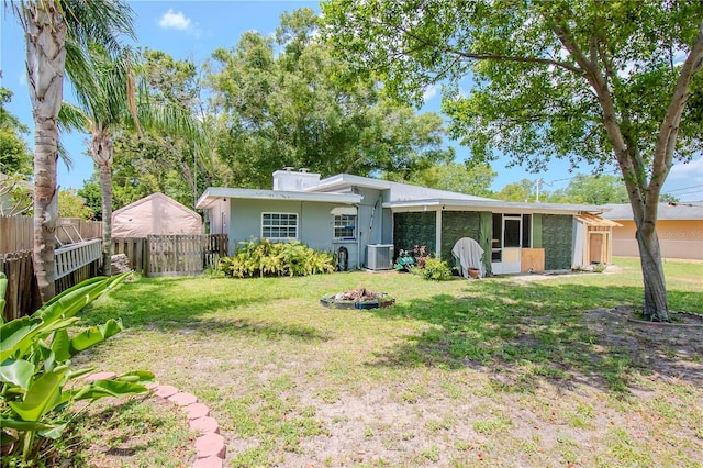 view of front of property with central AC unit and a front yard