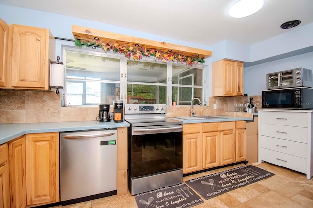 kitchen with appliances with stainless steel finishes, light brown cabinetry, sink, and tasteful backsplash