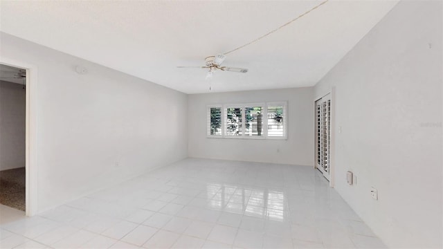 unfurnished room featuring ceiling fan and light tile floors