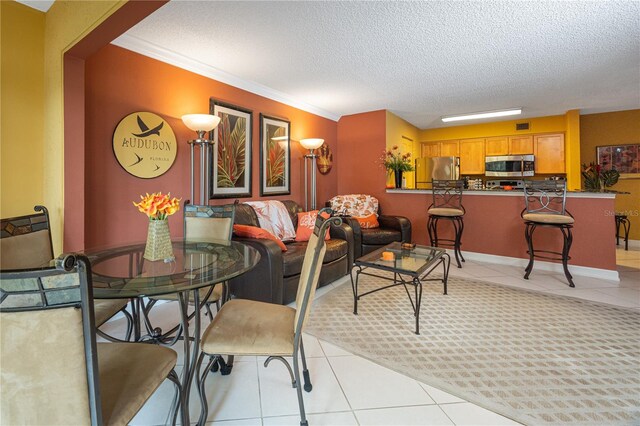 tiled dining area with ornamental molding and a textured ceiling