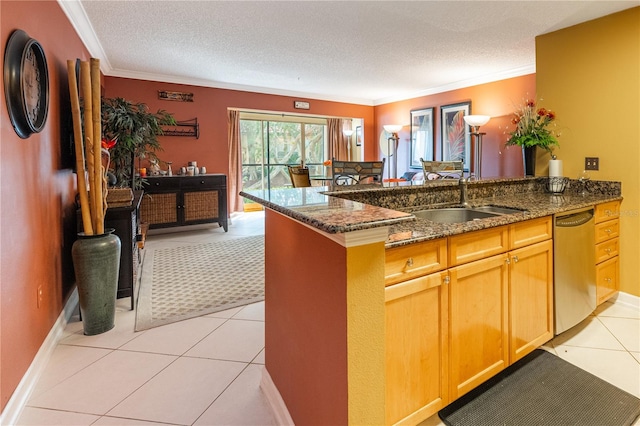 kitchen with dark stone counters, dishwasher, light tile floors, sink, and a textured ceiling