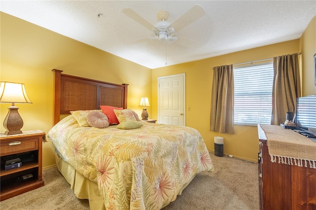 carpeted bedroom featuring ceiling fan and a textured ceiling