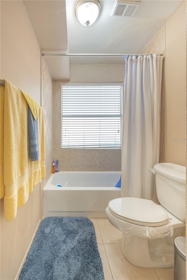 bathroom featuring shower / bathtub combination with curtain, toilet, and tile floors