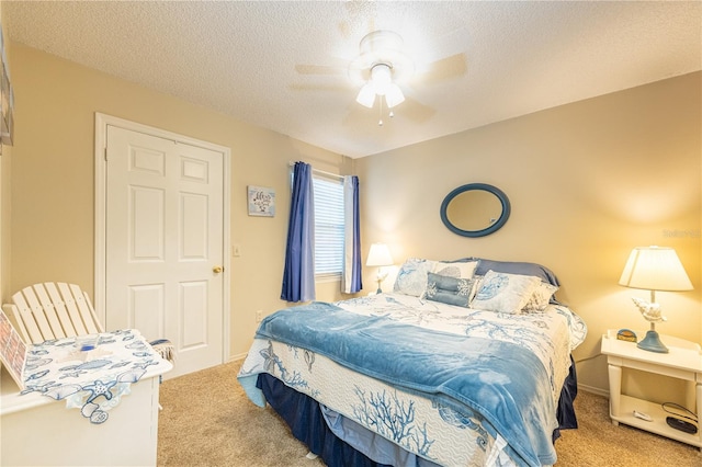 bedroom with carpet flooring, ceiling fan, and a textured ceiling